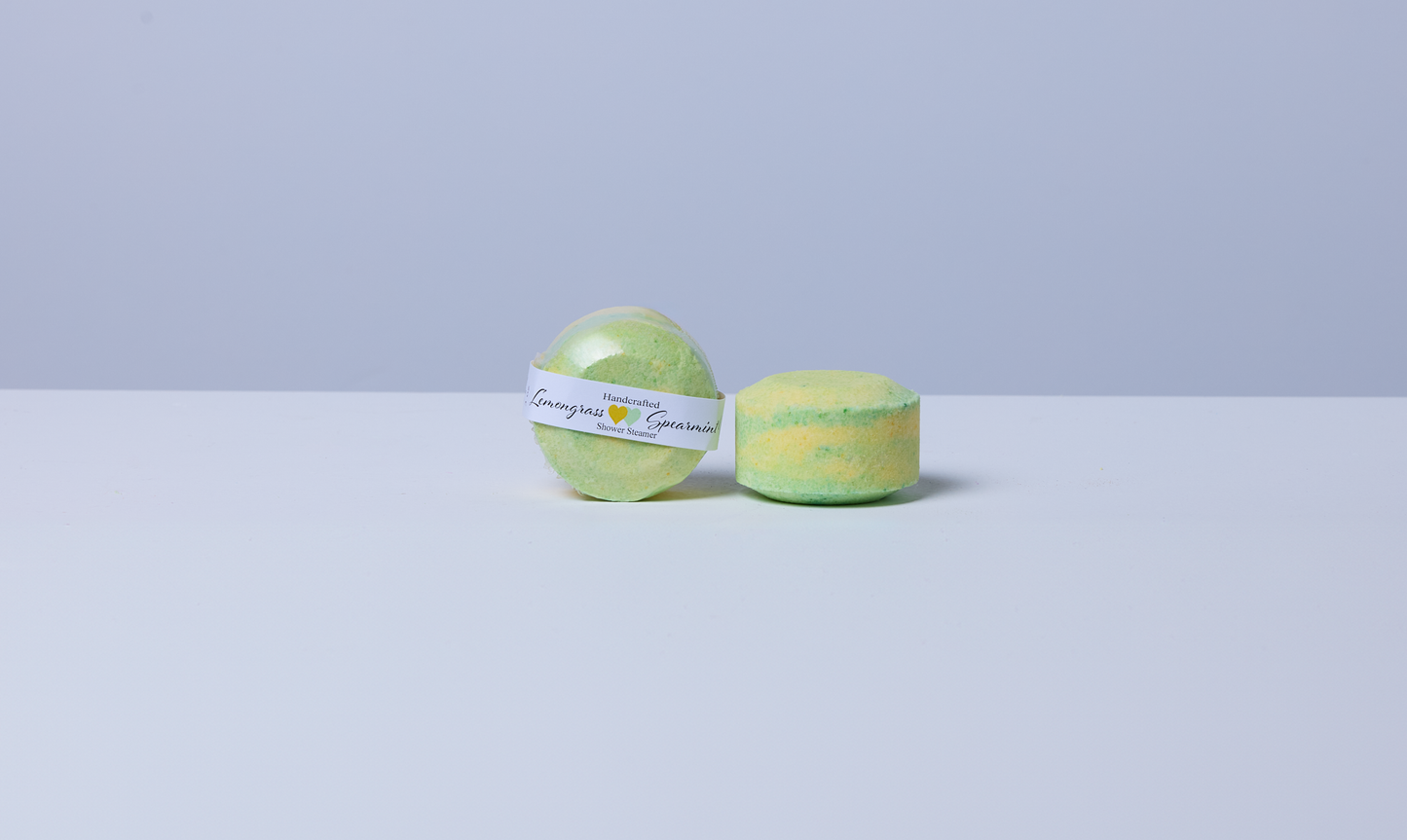 Lemongrass Spearmint Menthol shower steamer by Husk Her Happy shown packaged and unwrapped, handcrafted in yellow and green.