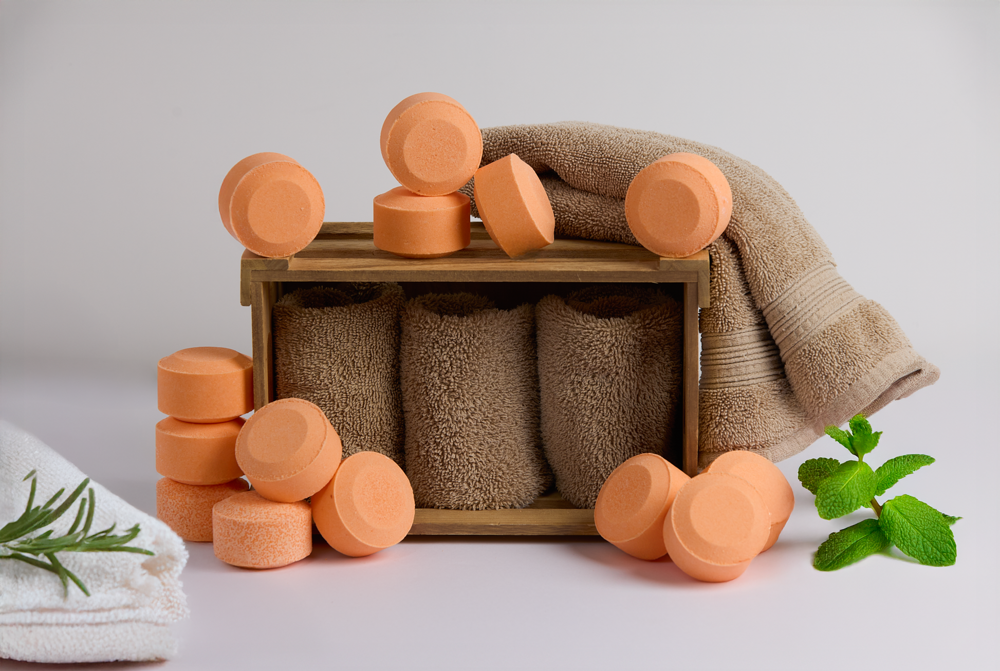 Rosemary Spearmint Menthol Shower Steamers displayed with spa towels, rosemary and mint